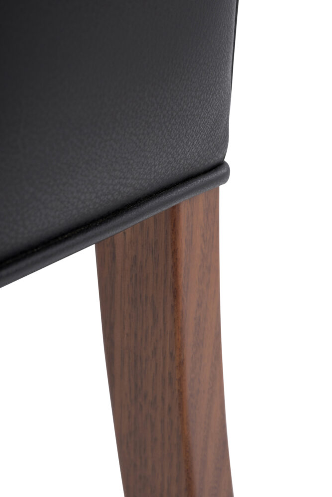 Adelaide, South Australian made solid timber Leone Low Back premium dining chair upholstered in black leather, view of leg detail.